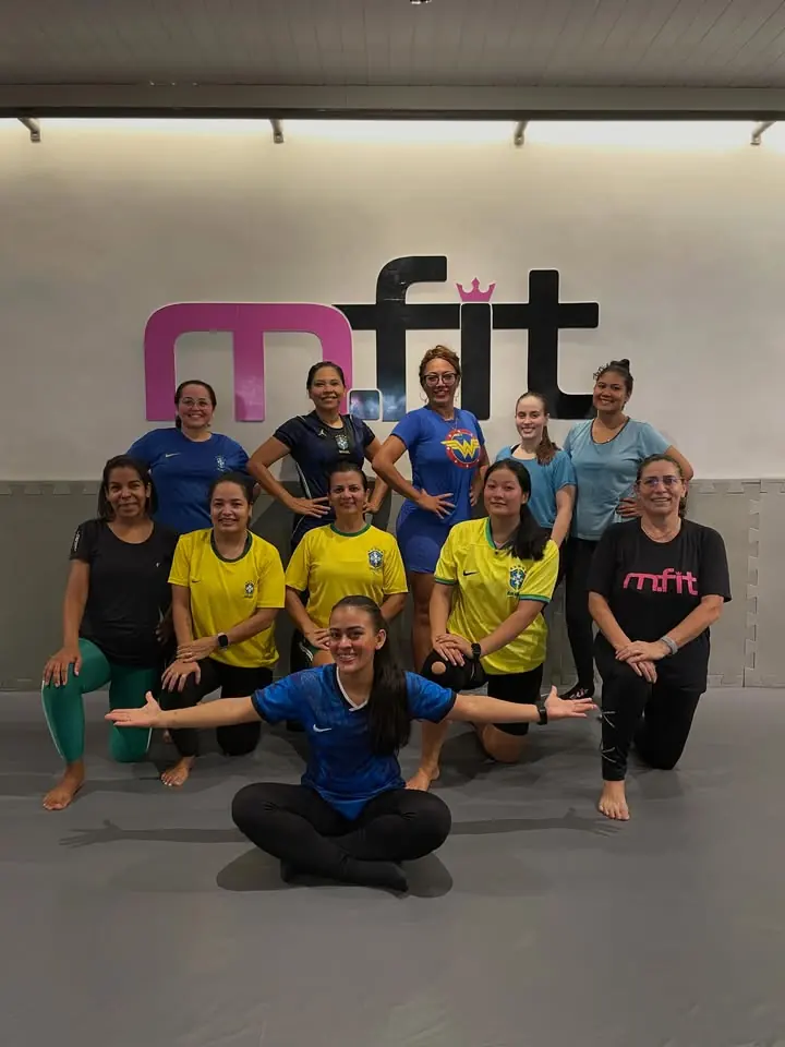 Turma do aulão de Tatame Fit reunida no tatame em frente ao logo