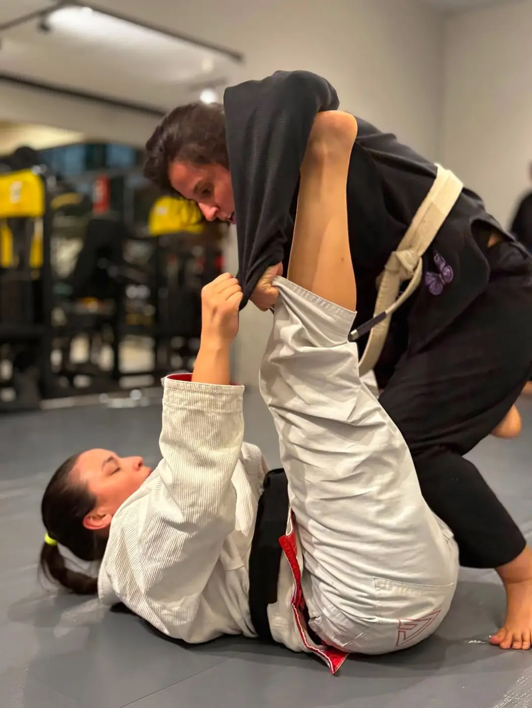 Duas alunas treinando jiu-jitsu de kimono no tatame da MFIT