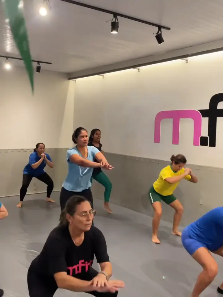 Alunas fazendo agachamento numa aula de Tatame Fit
